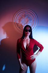 Hot sexy brunette in red and blue lights in studio