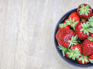 image of red strawberry in wooden background with space for text 