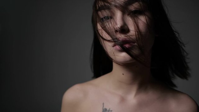 Asian girl is standing with face covered with hair