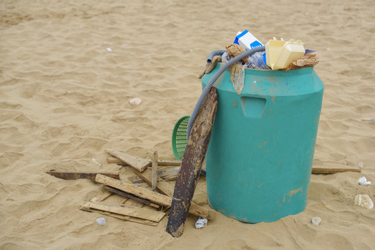 full trash can on the beach