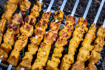 Grilled kebab cooking on metal skewer closeup. Roasted meat cooked at barbecue. BBQ fresh beef meat chop slices. Traditional eastern dish shish kebab. Grill on charcoal and flame picnic street food