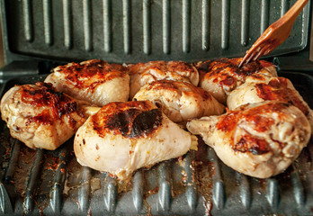 chicken meat is cooked on an electric grill