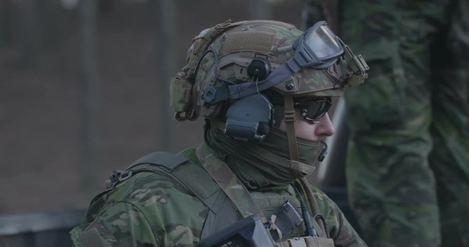 Special forces soldiers in a full combat uniform on a post in the woods