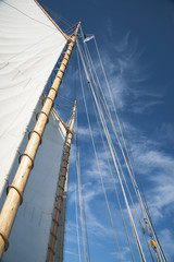 Fototapeta premium Sails and Wooden Masts of Old Schooner Sailboat Reaching to Blue Sky