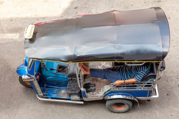 A tuk-tuk driver waits for customers on the street of Chiang Mai, Thailand.