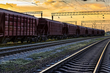 railcar for dry cargo during beautiful sunset and colorful sky, railroad infrastructure,...