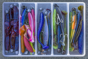 Fishing background of jig soft lures with hooks in box