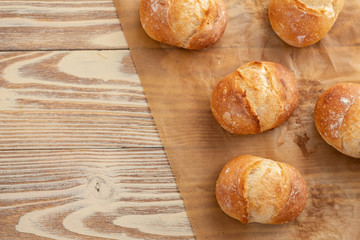 Assortment of baked bread on wooden table background. Copy space.