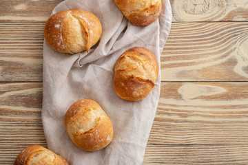 Assortment of baked bread on wooden table background. Copy space.