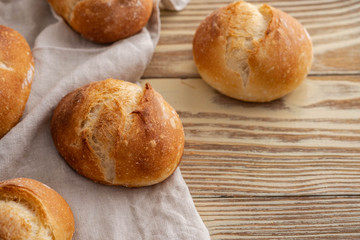 Assortment of baked bread on wooden table background. Copy space.