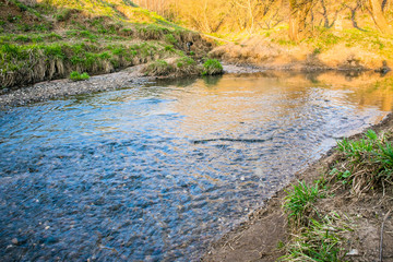 A calm flow of the Ramenka rivulet. Energizing spring sunlight awakens nature.