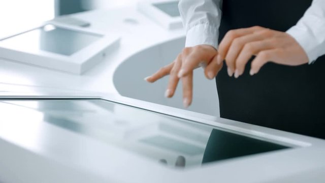 Close-up of hands touching modern screen in the hi-tech office or software lab