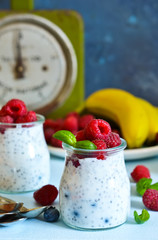 Vanilla yoghurt with raspberries and banana for breakfast. Dietary meals.