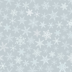 Christmas seamless pattern of snowflakes, white on light blue background.