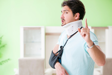 Young student man with neck and hand injury at home