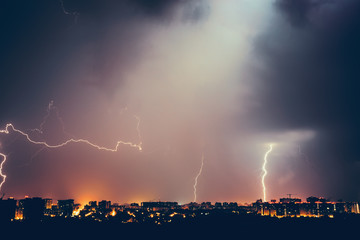 Thunderstorms vivid dramatic cloudy sky and lightnings above night city