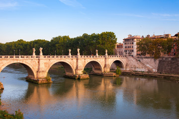 Panorama cityscape from the ancient embankment Tiber in Roma at sunset. Near of bridge and castle of Angels. Saint Angelo castle and bridge is famous tourist destination in Italy
