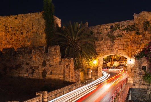 Night photo of ancient street in Rhodes city on Rhodes island, Dodecanese, Greece. Stone walls and bright night lights. Famous tourist destination in South Europe