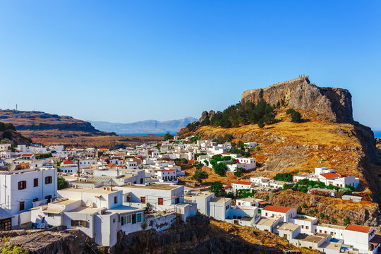 Skyview landscape photo Lindos town and ancient castle on Rhodes island, Dodecanese, Greece. Panorama with mountains and sea. Famous tourist destination in South Europe