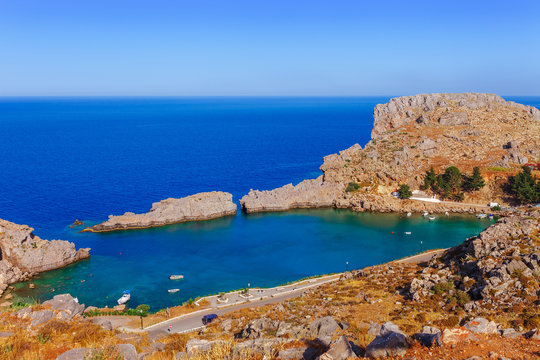 Sea skyview landscape photo Saint Paul bay in Lindos on Rhodes island, Dodecanese, Greece. Panorama with nice sand beach and clear blue water. Famous tourist destination in South Europe