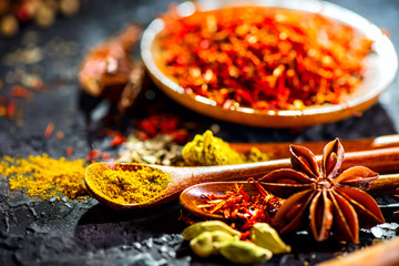 Spices. Various Indian spices on black stone table. Spice and herbs on slate background. Cooking ingredients