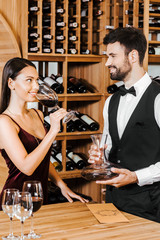 wine steward and client looking at each other during degustation at wine store