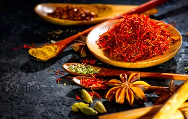 Keuken spatwand met foto Specerijen. Diverse Indiase kruiden op zwarte stenen tafel. Spice en kruiden op leisteen achtergrond. Ingrediënten koken © Subbotina Anna