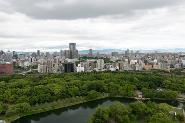 Fototapeta na wymiar Aerial view of moat around castle park, Osaka business district and spectacular mountains surrounding the city from Osaka Castle.