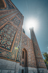 Fragment of Registan Square Minarett with sun and Madrasah complex in Samarkand, Uzbekistan