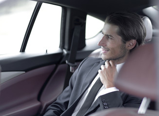 serious businessman sitting in car