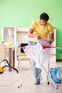 Leg injured man doing clothing ironing at home