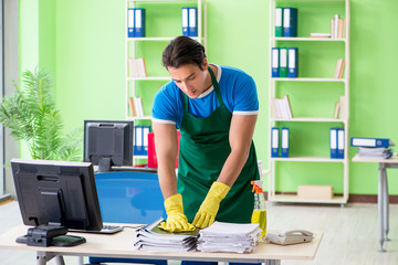 Male handsome professional cleaner working in the office