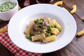 Plate with tortiglioni pasta onion and peas  