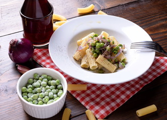Plate with tortiglioni pasta onion and peas  