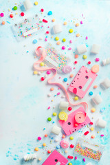 Pink cassette tapes in a sweet sounds concept. Candies, sprinkles and marmalades on a light background with copy space. Pastel color flat lay