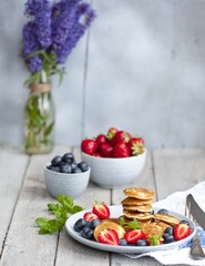 Fototapeta na wymiar Traditional danish pancakes - ebelskivers with fresh berries 