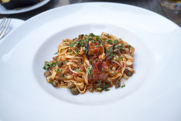 linguini pasta red tomato sauce mushrooms basil white plate restaurant 