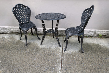 Cast iron table and chairs outside wet floor. 