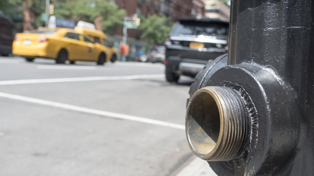 Open Spigot, Close Up, Fire Hydrant, Low Angle, Blurred New York City Street In Motion, Yellow Taxi