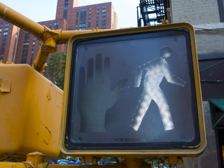 crosswalk city street sign showing walking icon that's it's ok to  walk