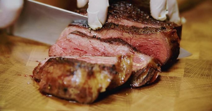 Professional chef is preparing steak in a modern restaurant