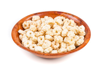Fototapeta na wymiar Piles of pale whole grain children's puffed cereal snack