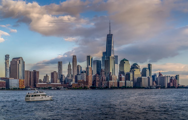 Fototapeta na wymiar Panorama view of NYC Lower Manhattan skyline with cruise ship passing by on Hudson River.