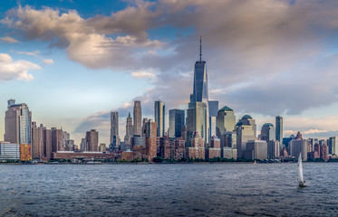 Fototapeta na wymiar Panorama view of NYC Lower Manhattan skyline with cruise ship passing by on Hudson River.
