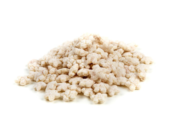 Piles of pale whole grain children's puffed cereal snack