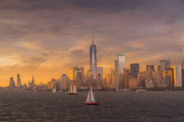Panorama view of  NYC Lower Manhattan skyline with sailboats passing by in New York Harbor