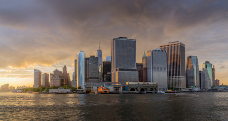 Fototapeta na wymiar Panorama view of NYC Lower Manhattan skyline with sailboat passing by in New York Harbor