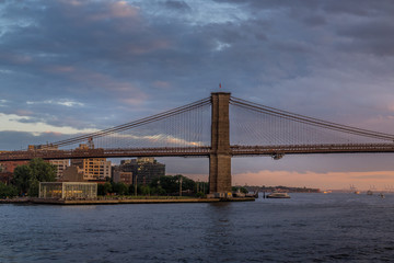 Fototapeta na wymiar Sunset view of Brooklyn Bridge on East River, NYC