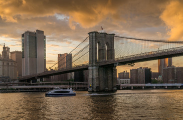 Fototapeta na wymiar Sunset view of Brooklyn Bridge on East River, NYC