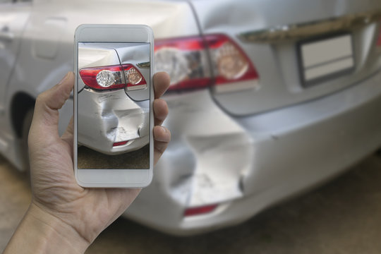 Hand holding smart phone take a photo at The scene of a car crash, car accident for insurance